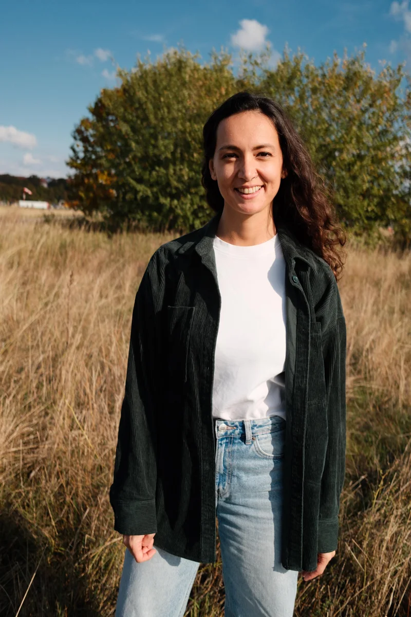 Benan standing outdoors in a dark jacket and jeans